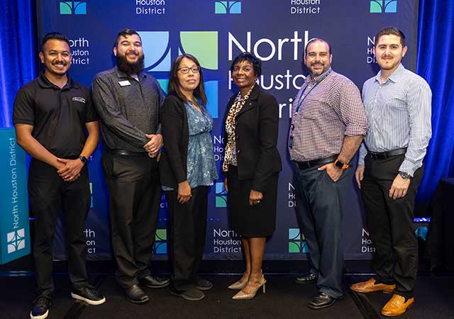 Tina Poindexter PS Awards 2025 Tina Poindexter stands with five other people in front of a North Houston District step-and-repeat backdrop during an event, all dressed in business or business-casual attire.